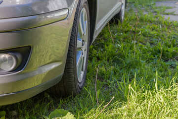 Front and side bottom car part with wheel on meadow