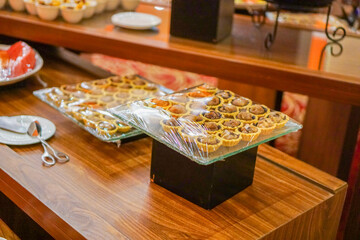 small cake snacks neatly arranged on a clear glass box plate for a treat at an event in a hotel