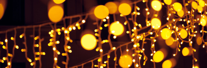 Blurred flickering lights of hanging garlands for New Year christmas street decorations at night,...