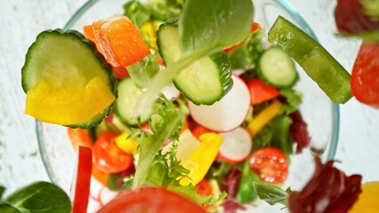 Top View of Flying Vegetable Pieces into Salad Bowl.