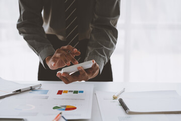 A male accountant or a business man uses a laptop to calculate investment results. And making financial reports on the desk Business finance accounting concept.