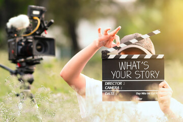What's your story. teenage boy holding a film slate or film clapper board. content creator, young...