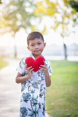 happy little boy holding a red heart-shaped toy on valentine's day