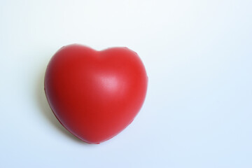 single red stress ball isolated on white background, heart shape toy
