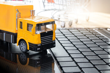 Logistics, Cargo car transport on the desk there is a computer and boxes of merchandise in the background. logistics and transportation service concept