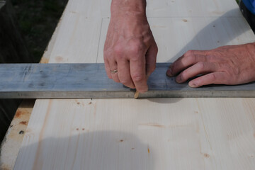 Carpenter's hands with a pencil. Carpentry tools. The man crafts at home.