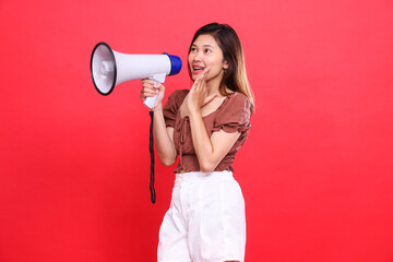 indonesia woman's gesture, shouting cheerfully, candidly holding an audio megaphone while focusing...