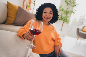 Photo portrait of lovely young lady sit floor drink wine alcohol dressed casual orange clothes cozy...