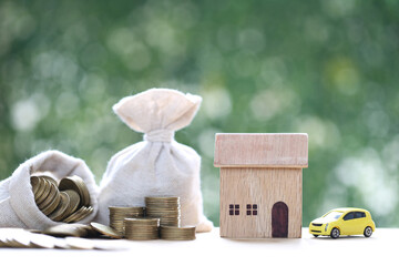 Model house with money bag and miniature car model on natural green background,Business investment and Save money for prepare in future concept