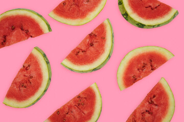 Summer fruit background concept, half round watermelon cuts spread out over pink background