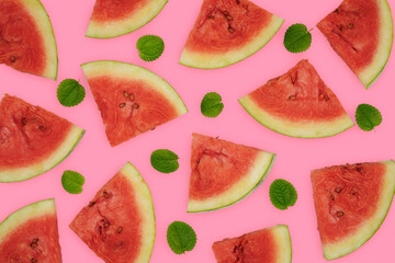 Summer fruit background concept, many cuts of watermelon with green leaves against pink background