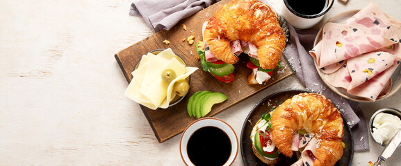 ..Croissant with ham and cheese on board and plate. Breakfast concept.