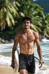 A young man walks along the beach carrying a surfboard under his arm