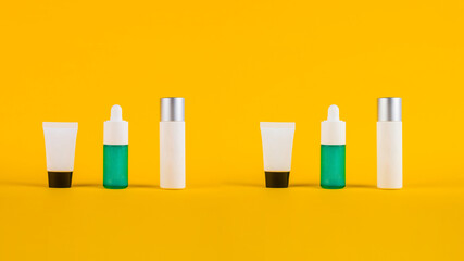 Blue glass cosmetic bottle, Skin care or sunscreen cosmetic with stylish props on white and yellow background.