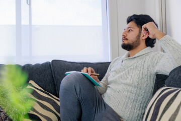 ノートを開いて真剣に悩む男性
