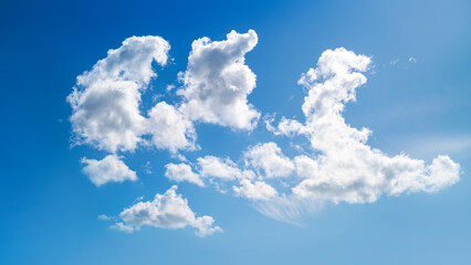 A spring, summer blue sky background with white fluffy clouds in a warm climate.