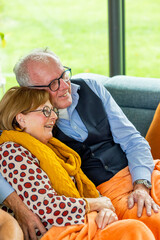 Elderly couple spending quality time on the couch, enjoying each others company and creating...