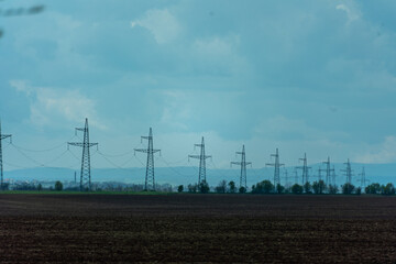 High voltage towers with sky background. Power line support with wires for electricity transmission. High voltage grid tower with wire cable at distribution station. Energy industry, energy saving