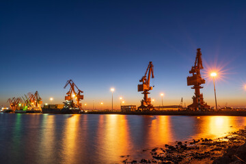 Gantry crane and cargo ship in the evening