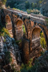 Scenic view of a stone bridge over a river with a majestic mountain in the background. Suitable for travel brochures or nature-themed designs