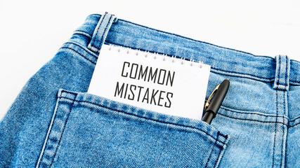 Common mistakes, text on a notebook from a pocket next to a pen