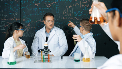 Smart teacher explain about chemical theory while student mixing colored solution or doing...