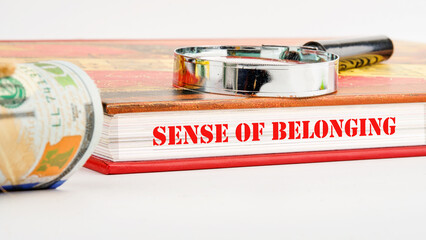 Business, sense of belonging concept. Text Sense of belonging on the pages of the book next to a...
