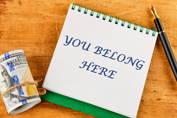 Diversity, business, inclusion and belonging concept. You belong here symbol on a notepad near...