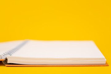 Orange book on yellow educational background White paper for studying and taking notes.