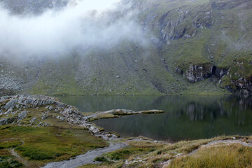 Landscape photo with a view of the lake Balea and mountains in the morning fog on Transfagarasan...