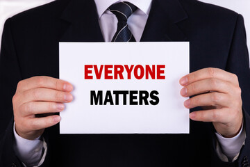 Businessman holding a card with text everyone matters