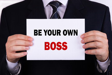 Obraz premium Businessman holding a card with text be your own boss