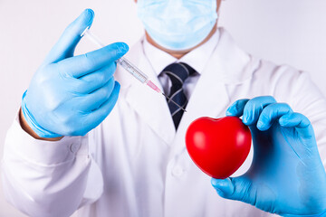 Close up of man hands with heart and a medical syringe for injection