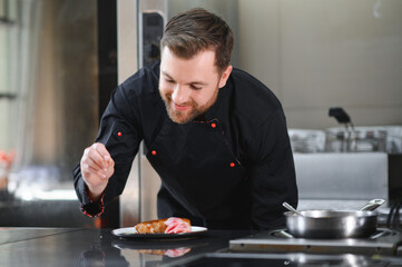 Portrait of handsome positive chef cook at the restaurant kitchen
