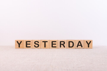 Word YESTERDAY made from wooden cubes on a light background