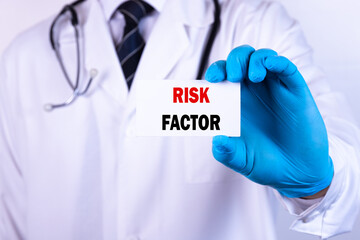 Doctor holding a card with text Risk Factor medical concept