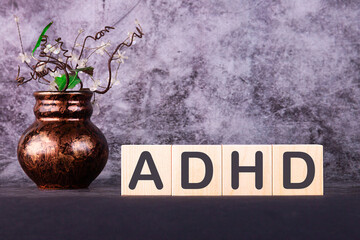 ADHD Abbreviation on ADHD cubes on a grey background. Close ADHD - Attention Deficit Hyperactivity Disorder.