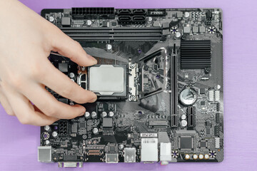 system administrator installing central processor unit into motherboard, assembling PC of different accessories or components, close-up view of hands, computer repair and maintenance concept