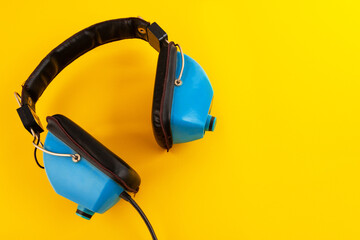 Vintage blue headphones on a yellow background