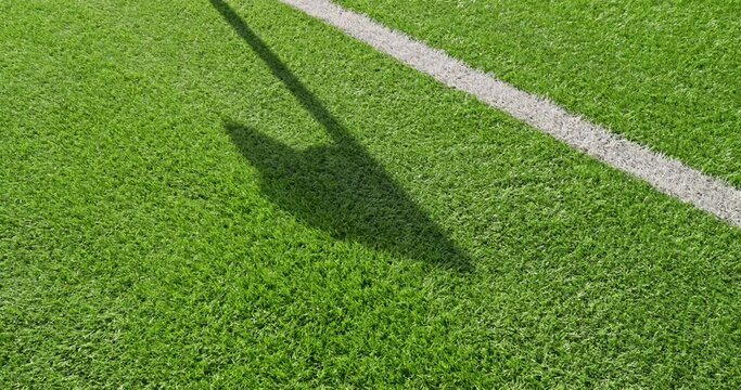 Soccer field impressions  -  Shadow of a corner flag waving in the breeze - panning shot