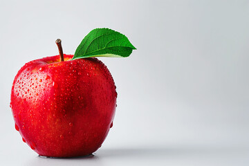 Close-up of a vibrant red apple with water droplets and a green leaf, isolated against a clean white background, illustrating freshness, healthiness, and natural food concept