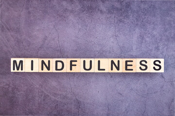 Word Mindfulness written on wooden cubes on a grey background