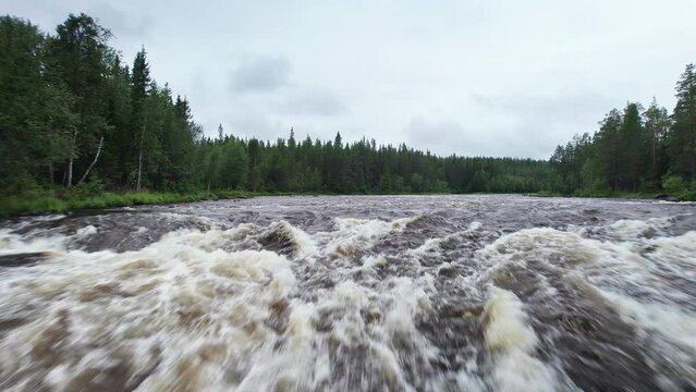 Beautiful aerial view rising low to high over the Klingforsen rapids of a forest river Stor&aring;n in Dalarna Sweden, showcasing the rushing water and surrounding greenery.
