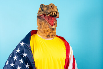 Person in dinosaur mask wrapped in USA flag showing pride