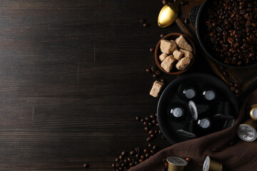 Coffee capsules, coffee beans and sugar on wooden background, space for text