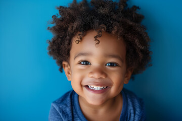 Happy child portrait. Little African American kid boy on blue background