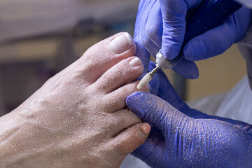 Young woman getting Pedicure with milling cutter in beauty salon, closeup