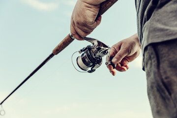 Freshwater fishing in summer. A fisherman using a spinning with a spinning reel to catch predatory...