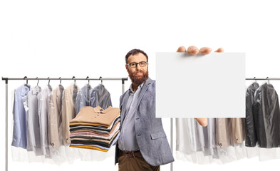 Man with a pile of folded clothes holding a blank card