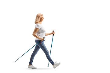 Full length profile shot of a middle aged woman with walking poles